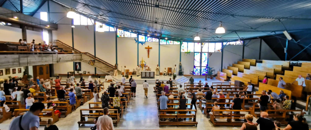 Interno della chiesa di San Pio X durante una messa.